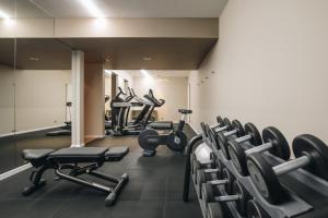 a gym with rows of dumbbells and weights at DelleArti Design Hotel in Cremona