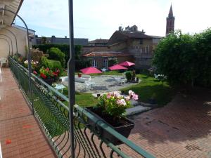 d'un balcon avec vue sur une cour fleurie. dans l'établissement Logis Hôtel L'Arche de Noé, à Noé