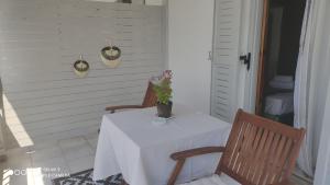 a white table with two chairs and a vase with flowers on it at Iason studio 4 in Patitiri