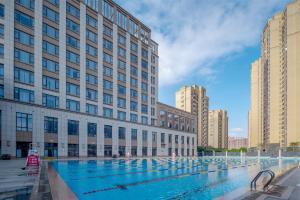 a large swimming pool in front of a building at Holiday Inn Express Jinjiang Anhai by IHG in Jinjiang