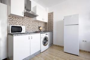 a kitchen with a washing machine and a refrigerator at Apartamento Betty F in Puerto del Rosario +12 photos