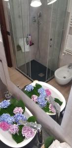 a bathroom with purple and pink flowers in a sink at Santa Maura in Vico Equense