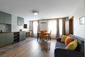 a living room with a couch and a table and a kitchen at Hotel Albatros Old Town in Sozopol