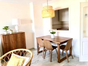 トレモリノスにあるInspiring Apartment in Carihuela Beachのダイニングルーム(木製テーブル、椅子付)