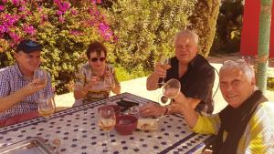 un gruppo di persone seduti a un tavolo con bicchieri da vino di Riad-villa Le Jardin aux Etoiles a Sidi Boumoussa
