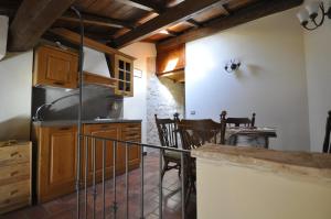 une cuisine avec des placards en bois et une table avec des chaises dans l'établissement Relax Colleverde, à Colle Verde