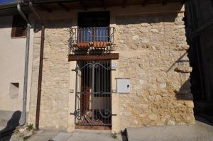 a stone building with a gate and a balcony at Relax Colleverde in Colle Verde