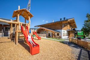 a playground with a slide in front of a building at Bauernhof Vorderklinglhub in Flachau