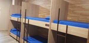a room with three bunk beds with blue pillows at albergue a queimada in Caldas de Reis