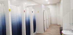 rząd straganów w łazience z umywalką w obiekcie ALBERGUE A QUEIMADA Exclusivo Peregrinos w mieście Caldas de Reis