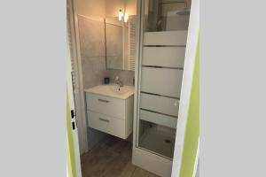 La petite salle de bains est pourvue d'un lavabo et d'un miroir. dans l'établissement Appartement T2 27m² meublé vue mer, 50m de la plage, à Narbonne