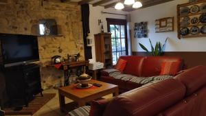 uma sala de estar com um sofá de couro e uma lareira em La Grange de Champagnac em Yvrac-et-Malleyrand