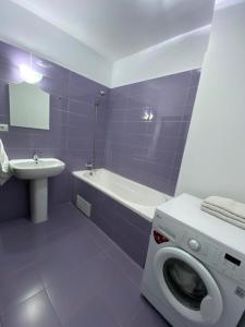 AMG Apartament في براشوف: حمام مع غسالة ومغسلة