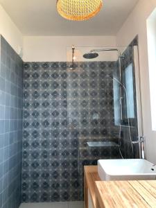 y baño con ducha de azulejos negros y lavamanos. en Nouveau: La cabine du bout du monde - Petit Minou - : votre pied-à-terre breton haut standing [PL01], en Crozon