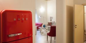 ジュルディニャーノにあるLe Tre Grazie B&Bの赤い冷蔵庫、リビングルームが備わる客室です。