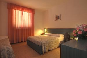 a bedroom with a bed and a table with a vase of flowers at Frank's Hotel in Capoliveri