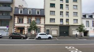two cars parked in a parking lot in front of a building at CHARNER centre gare 2 chambres 100m2 parking in Saint-Brieuc