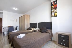 a hotel room with two beds and a desk at Apartamento Betty G in Puerto del Rosario