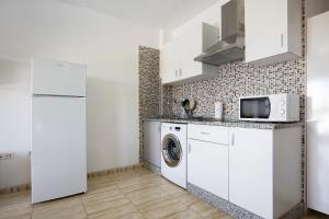 a kitchen with a washing machine and a refrigerator at Apartamento Betty G in Puerto del Rosario