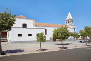 a church with a white building with a steeple at Apartamento Betty G in Puerto del Rosario