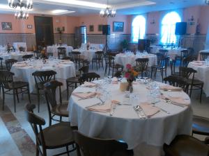 a room filled with tables and chairs with white table cloths at Hotel Chipiona in Chipiona