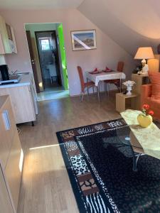 a living room with a kitchen and a table with a rug at Villa Sonnenschein in Hévíz