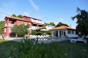 a house with a swimming pool in front of a house at Apartment in Mundanije with balcony, air conditioning, WiFi (4912-1) in Mundanije