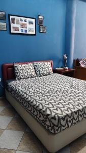 een bed in een kamer met een blauwe muur bij Studio BLU in Xylophaghou