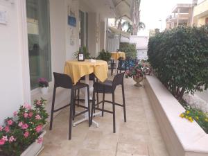 a table and chairs on a balcony with flowers at Falli Exclusive Rooms and Breakfast -Boutique B&B- in Porto Cesareo