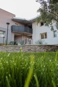 une maison blanche avec une clôture et de l'herbe devant elle dans l'établissement Villa San Martino - bilocale a Bussolengo, à Bussolengo