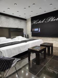 une chambre d'hôtel avec un grand lit et deux tables dans l'établissement Hotel Plata by Bossh Hotels, à Ibi