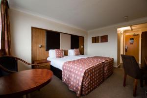 a hotel room with a bed and a table at Muthu Glasgow River Hotel in Erskine