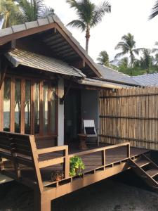 a house with a wooden deck with a bench at Jasmine & Tea House in Mae Nam