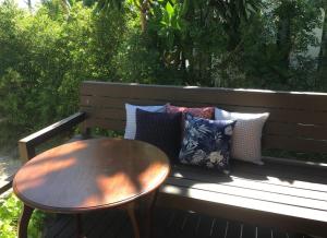 a wooden bench with a table and pillows on it at Jasmine & Tea House in Mae Nam