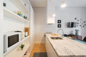 eine Küche mit einer Spüle und einer Mikrowelle in der Unterkunft OPO Downtown Blue in Porto