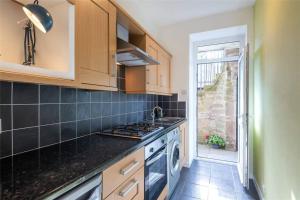 uma cozinha com fogão forno superior ao lado de uma janela em The Colours Riverside apartment with garden em Broughty Ferry