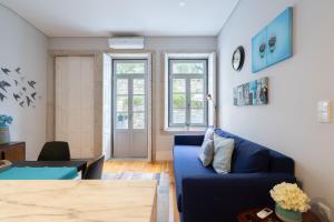 a living room with a blue couch and a table at OPO Downtown Blue in Porto