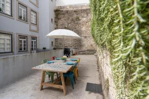 a table with chairs and an umbrella on a patio at OPO Downtown Blue in Porto