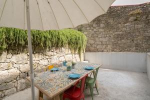 einen Tisch mit blauen Tellern und einem Regenschirm in der Unterkunft OPO Downtown Blue in Porto