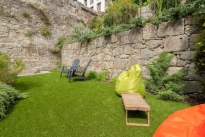 a garden with a table and chairs and a stone wall at OPO Downtown Blue in Porto
