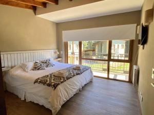 um quarto com uma cama e uma varanda em Altos del Bonito em Villa La Angostura