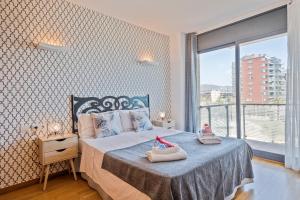 a bedroom with a bed with shoes on it at Alcam Badalona Playa Norte in Badalona +44 photos