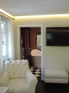 ein Wohnzimmer mit einem weißen Sofa und einer Badewanne in der Unterkunft Pension am Bodensee (Adults only) in Kressbronn am Bodensee