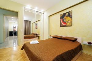 a bedroom with a large bed and a mirror at Centr kvartir 5 in Minsk