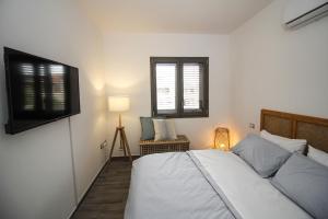 a bedroom with a bed and a window at Casa Kant in SantʼAntìoco