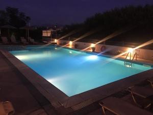 ein großer, nachts beleuchteter Pool in der Unterkunft Litus Amoris in Sidari