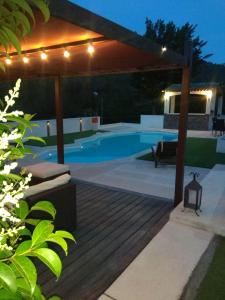 a swimming pool in a backyard at night with lights at Lobeal in Auriol