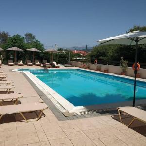 uma grande piscina com cadeiras e um guarda-sol em Litus Amoris 2 em Sidari