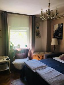 a bedroom with two beds and a window and a chair at Studio apartman Zagreb zapad Vrapče in Zagreb