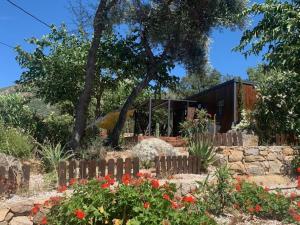 a garden with a fence and flowers in front of a house at Location du Ranch Cantarettu in Algajola +26 photos